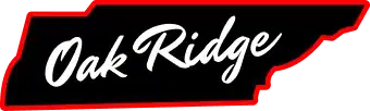 A black sign with the words "Oak Ridge" in white cursive, outlined by a red border shaped like the state of Tennessee.