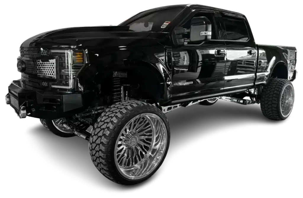 A lifted black pickup truck with oversized tires and chrome details displayed against a white background.