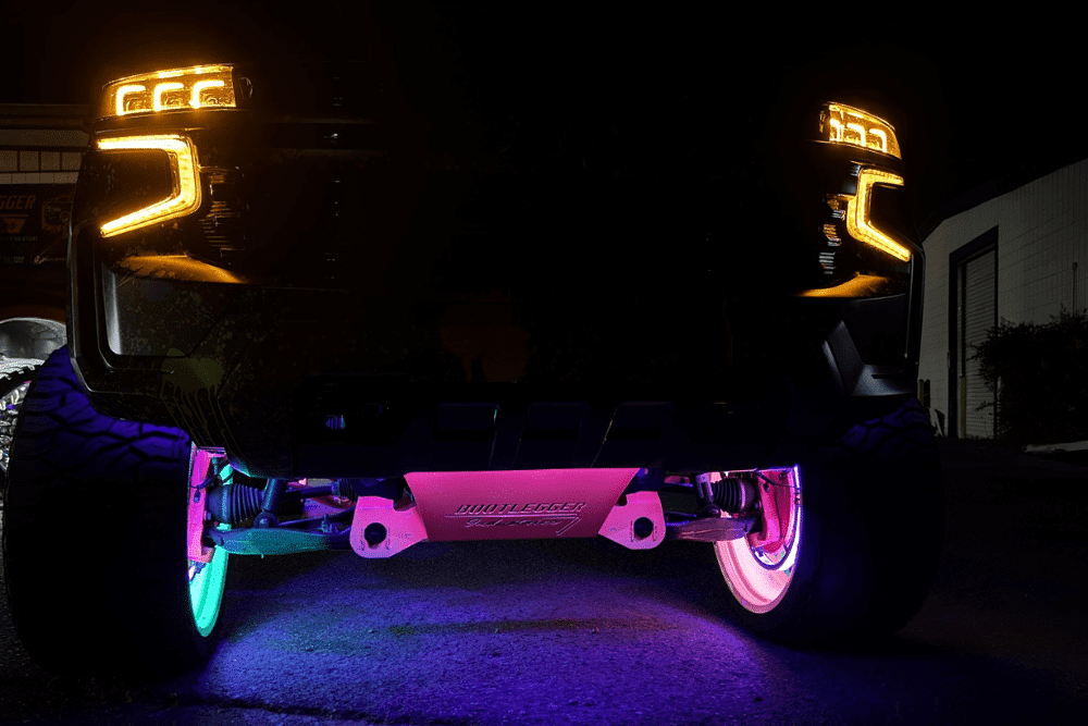 Custom headlights, custom lighting in Oak Ridge, TN by Moonshine Diesel. Image showing a lifted truck with vibrant underglow and illuminated suspension, highlighting performance upgrades and unique styling modifications for diesel enthusiasts.